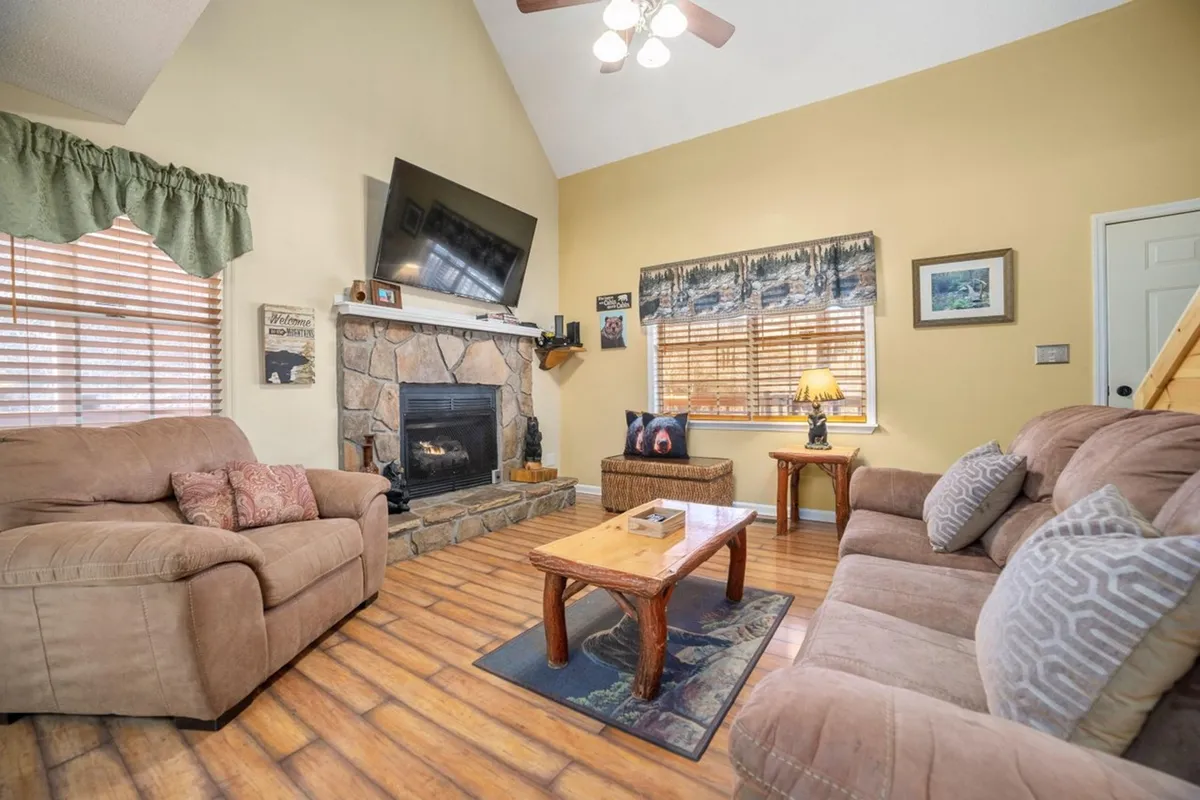 A cozy living room with a sofa, fireplace, wooden coffee table, and mounted TV—perfect for relaxing or enjoying a movie night after a day out. The scene suggests warmth and togetherness, inviting groups to unwind and share stories.